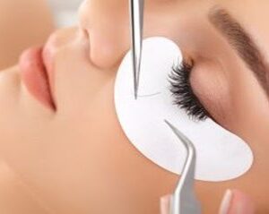 A woman receiving eyelash extension treatment